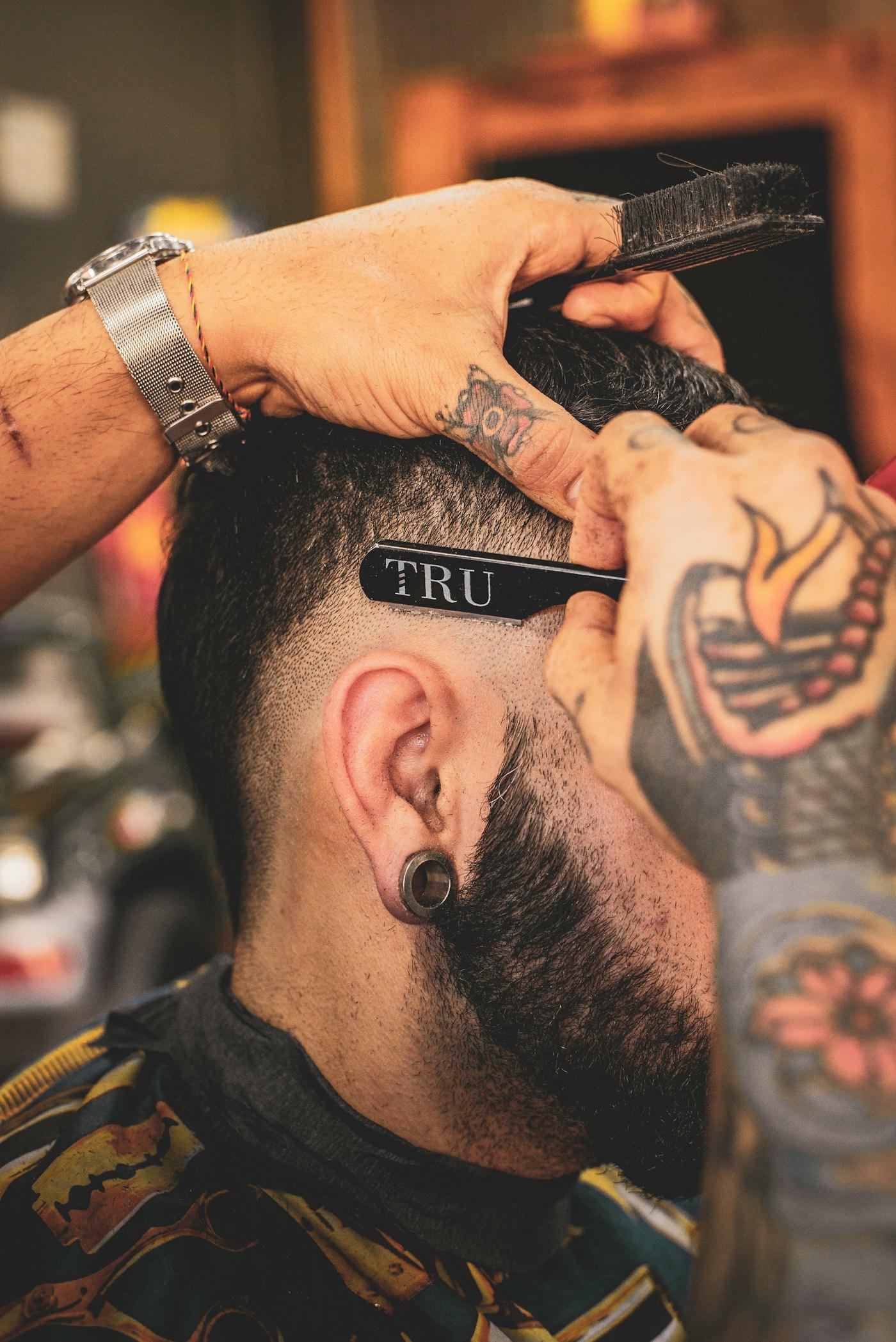 Barber sculpting a client's beard